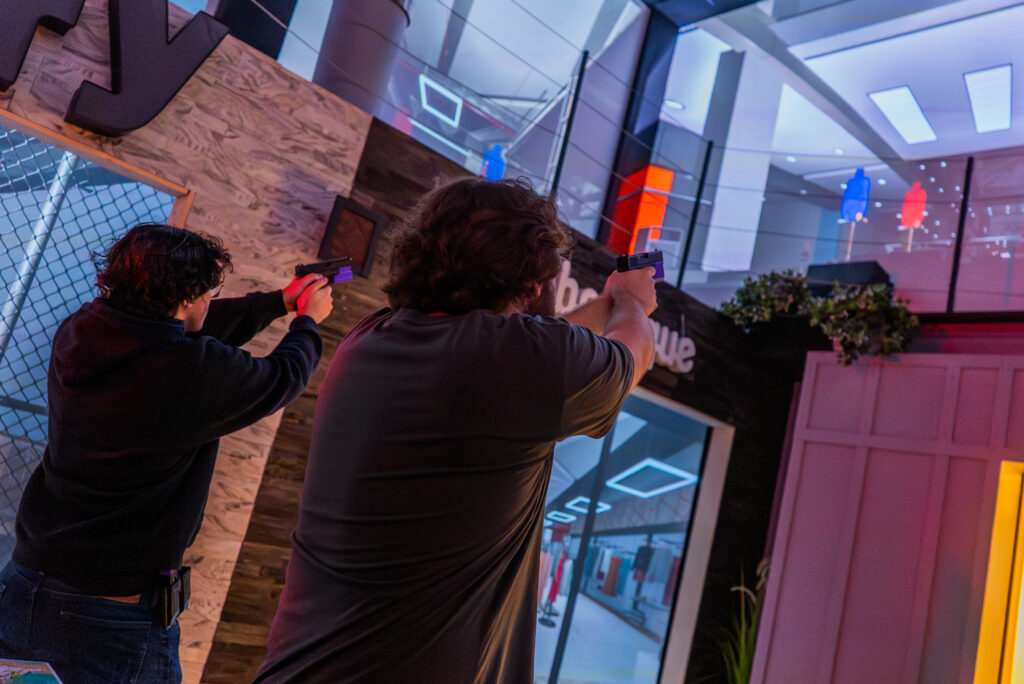 Visitors trying a safe simulation pistol challenge inside Decision Tactical’s immersive indoor theme park in Orlando