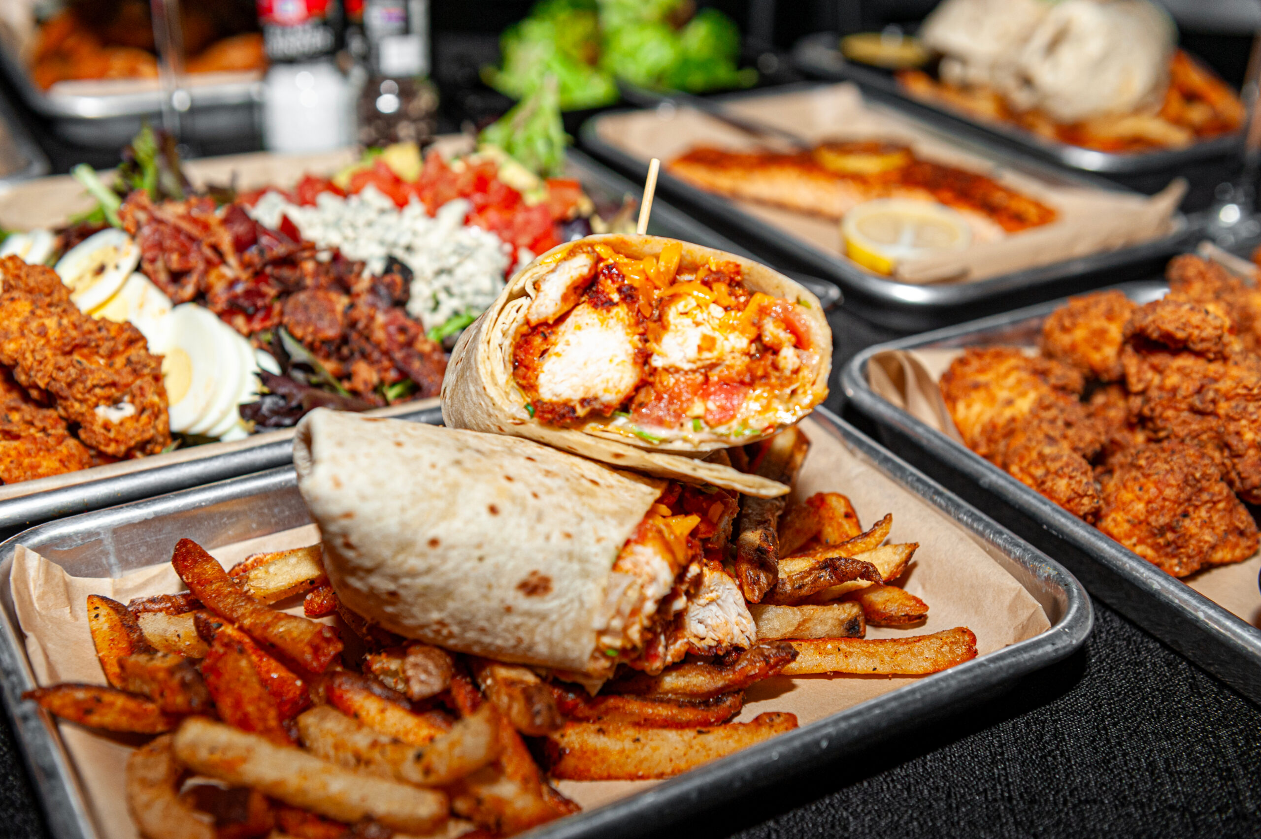 Buffalo chicken wrap with fries and appetizer spread at the DTAC Bar & Grill — full-service restaurant inside Decision Tactical's tactical theme park in North Orlando