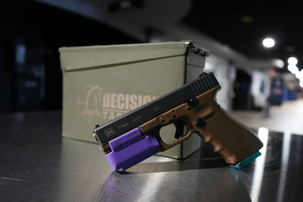 Modified Glock training firearm with CO2 magazine attachment at Decision Tactical in North Orlando — real firearm frame modified to fire zero live projectiles, safe for all guests